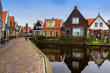 Traditional houses near canal in Holland town Volendam, Netherlands, in a spring day.の写真素材
