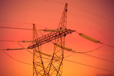 Pylon and transmission power lines in sunset