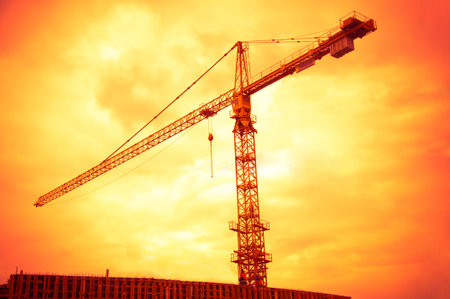 big crane on the sunset orange sky background
