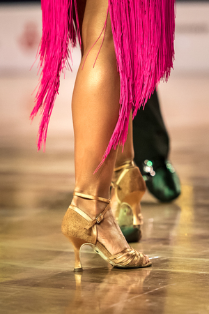 Beautiful womanish and masculine legs in active ballroom dance, indoorsの写真素材