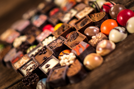Assorted chocolate pralines on the wooden backgroundの写真素材