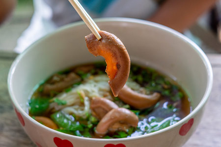 Thai noodle soup with pork and mushroom in a bowl.の写真素材