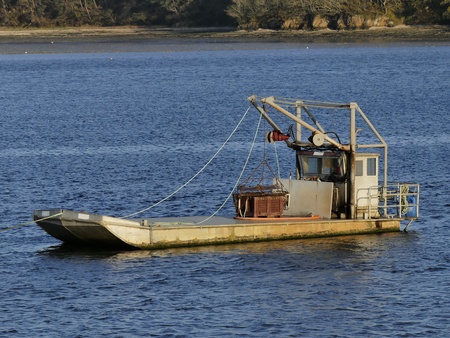 Small oyster boat at anchor for the night. Horizontal view from port side bowの写真素材