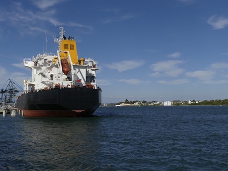 Products Tanker discharging at the Oil Terminal of Lorient, France, with black hull and yellow funnel on a sunny dayの写真素材