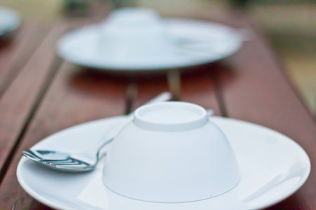 White Sphere Bowl, Dish and Stainless Spoon on Wood Tableの写真素材