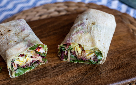 Vegetarian Wraps with beetroot, red cabbage, arugula and humus served on a wooden tray