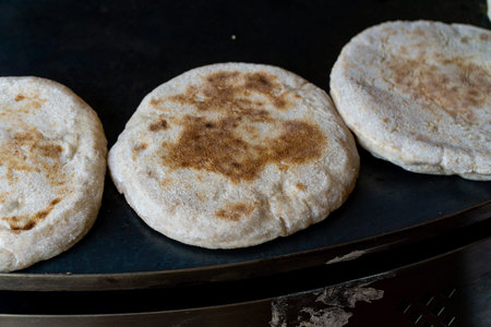 Baking pita bread, small fluffy breads. Also known as pide or bazlama. Showing multiple small breads