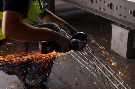 Industrial worker, cutting metal with grinder. Sparks visible. Concept for industrial, metal work....