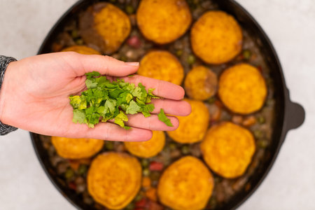 Baked sweet potatoe and pea curry.  Baked sweet potatoe with cooked vegetables, served in an iron cast pan.の写真素材