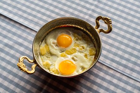sunny side up eggs with cheese, breakfast served in copper panの写真素材
