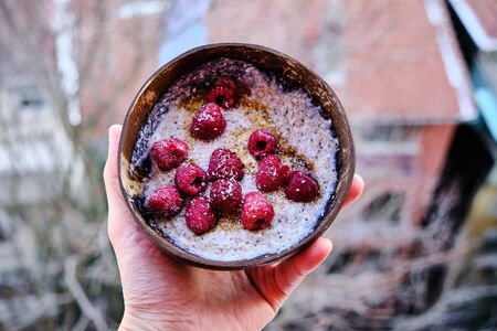 yoghurt with teff and quinoa topped with raspberry, coconut flakes and maple syrup. homemade healthy snackの写真素材