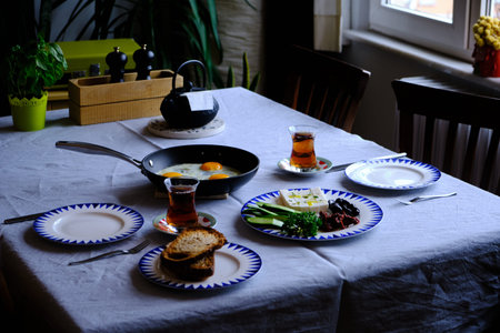 Traditional Turkish Breakfast with Sunny Side Up Eggs, Feta Cheese, Tea, Olives and Cucumber. Breakfast for twoの写真素材
