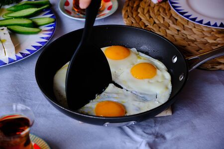 Traditional Turkish Breakfast with Sunny Side Up Eggs, Feta Cheese, Tea, Olives and Cucumber. Breakfast for twoの写真素材