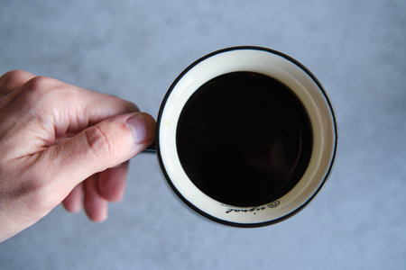 Cup of black coffee in a handmade white ceramics mug, white marble background