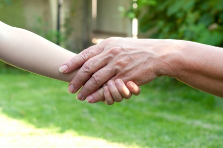 hands of young child and old senior outsideの写真素材
