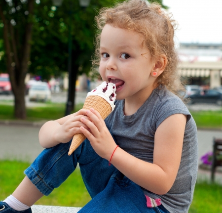 Happy girl with ice cream outdoorsの写真素材