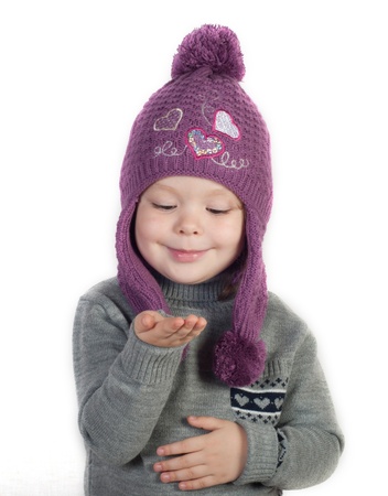 Little girl in winter clothes with empty handの写真素材