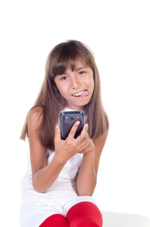 little girl with smartphone with tongue out isolated on whiteの写真素材