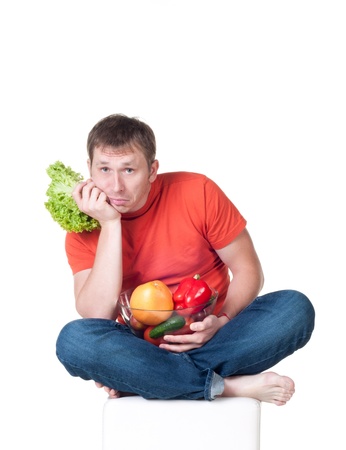 Young man with plate of fresh healthy vegetables on white backgroundの写真素材