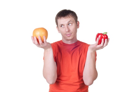young man hold in his hand fresh pepper and grapefruit, isolated on whiteの写真素材