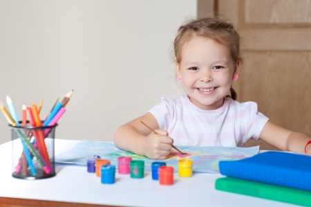 Little cute girl painting with brush の写真素材