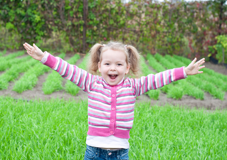 open arms little happy girl green meadowの写真素材