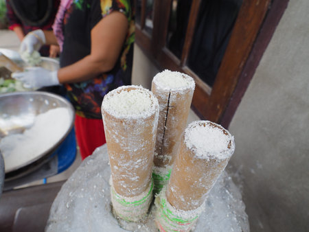 Khanom Bork name of this thai tradition dessert made form coconut rice flour and some salt put in bamboo stick and steamed with boiled water eat with fresh coconut, this dessert is pumrieng tradition food you can find it only at Pumrieng market, Surattani, Thailandの写真素材