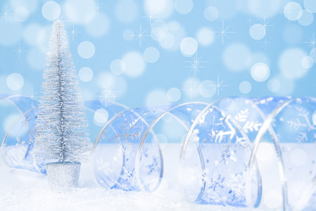 Blue bokeh background of silver christmas tree with copyspace for textの写真素材