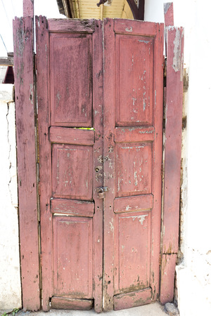 Red wood door old in lampang thailandの写真素材