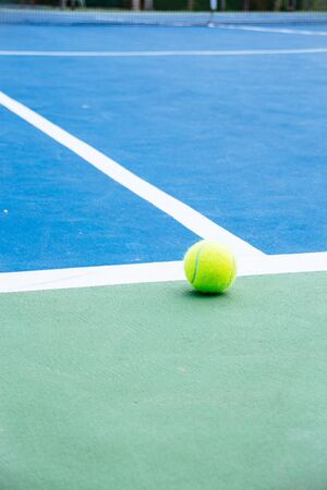 blue and green tennis court surface,Tennis ball on the field.の写真素材