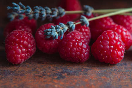 Raspberries and dry lavender sprigs on a rough surfaceの写真素材