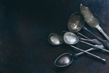 Silver set of vintage cutlery on a dark background, top view with a copy spaceの写真素材