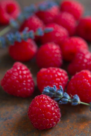Raspberries and dry lavender flowers on a rough surfaceの写真素材