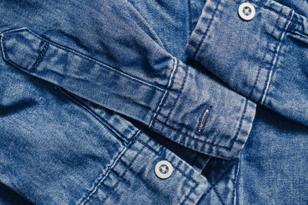 Blue denim clothing with buttons, top view background