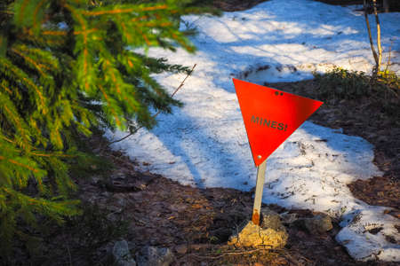 Red triangle sign in the spring forest bewaring of minesの写真素材