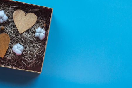 The craft gift box with the heartcard and cotton flowers on the blue background