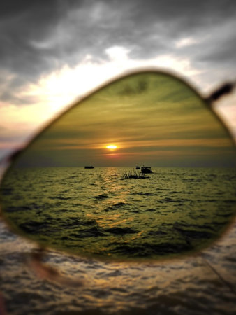 Reflection of the sunset in the mirror of a boat in the sea