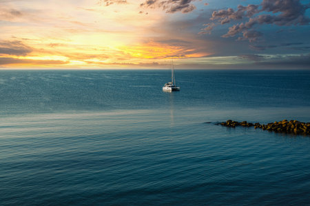 Sailing boat in the morning sun on the coastの写真素材
