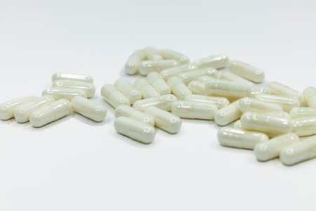 Close up of a pile of white capsules pills. Medications on white backgroundの写真素材