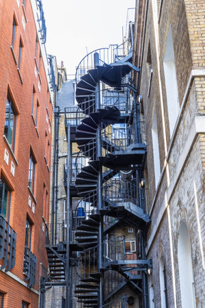 Outdoor Emergency Spiral Staircase Winding Between Urban Architectureの写真素材