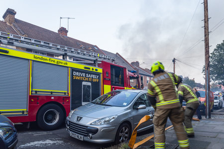 Firefighters in Action. Emergency Scene with Fire Engine in a Residential Area