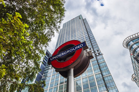 London Underground Sign with Modern Skyscraper and Urban Skyline in the Backgroundの写真素材