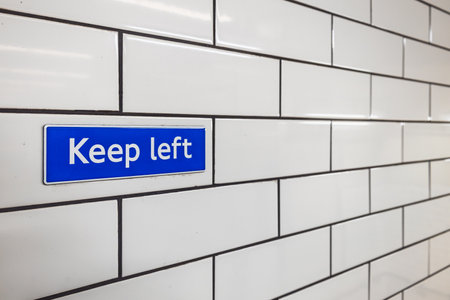 Keep Left sign on white tiled wall inside London Underground stationの写真素材