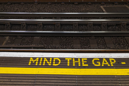 Mind the Gap Warning Sign on London Underground Platform Edge for Passenger Safetyの写真素材