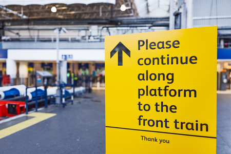 Clear Yellow Directional Sign Guiding Passengers to Continue Along Platform Front Lineの写真素材