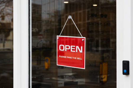 Glass Door with Red - Open - Sign and Instruction to Ring the Bell for Entryの写真素材