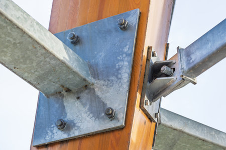 Industrial Steel Beam Connection with Bolts and Wooden Supportの写真素材
