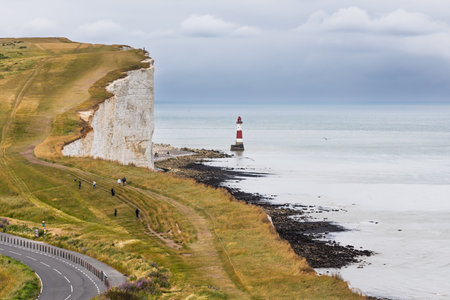 Beachy Head white chalk cliffs and red-white lighthouse, South Downs, East Sussex coast, UKの写真素材