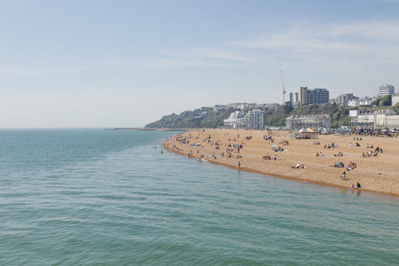 People relaxing on the pebble beach in Folkestone, Kent