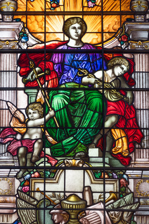 Classical stained glass window with a central figure and cherubs. London, UK, 16 June 2024のeditorial素材